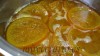 La naranja con el agua y el azúcar a fuego lento.